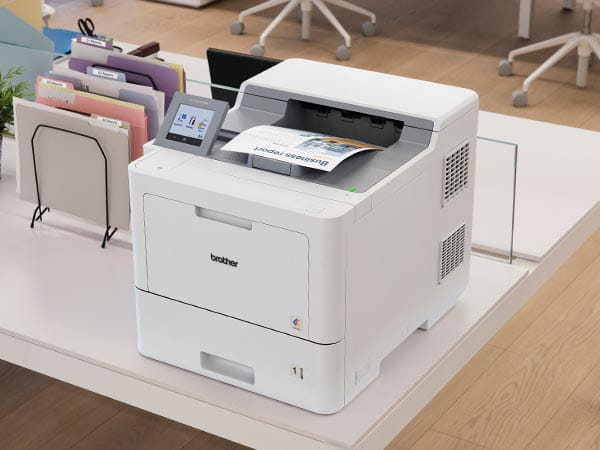 Printer on desk on corporate office, with business report in output tray