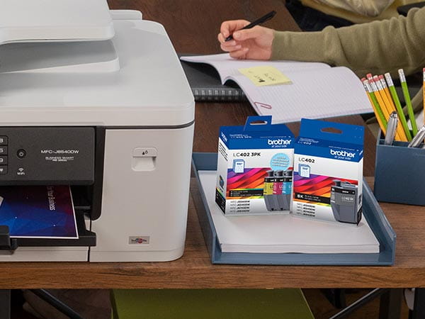 Printer on desk with replacement ink cartridge packaging