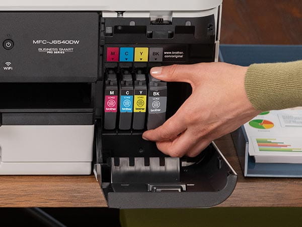 Woman placing new ink cartridge into printer