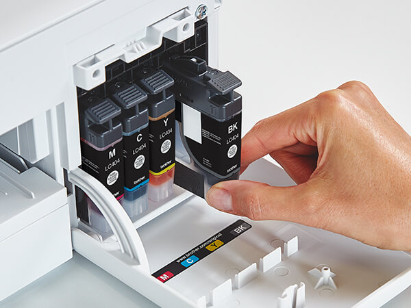 Person inserting new Brother Genuine LC404 ink cartridge into printer