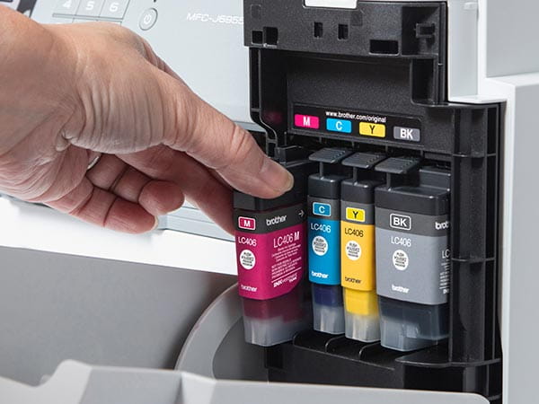Person loading new magenta ink cartridge into printer