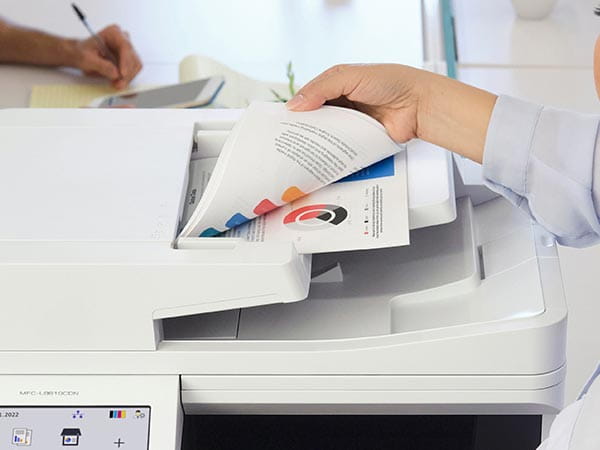 Person loading multipage duplex document into automatic document feed for scanning