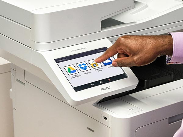 Person using printer's touchscreen to select print-from/scan-to location: Google Drive, Dropbox, SharePoint, or OneDrive