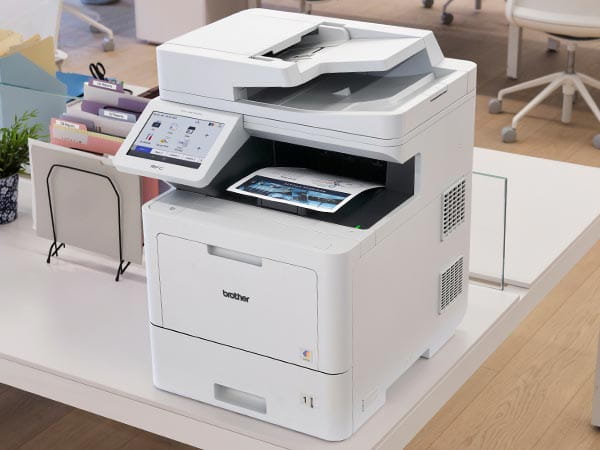 Printer on desk on corporate office, with company's global charter in output tray