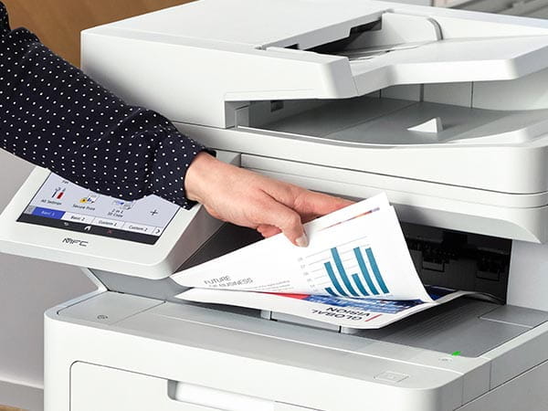 Person removing double-sided color business report from printer's output tray