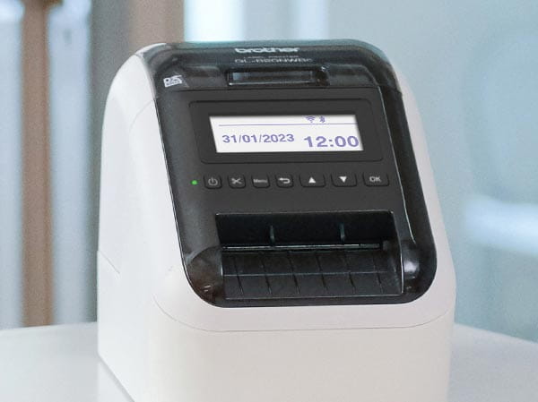 Label printer displaying time, date, and wireless status on LCD screen