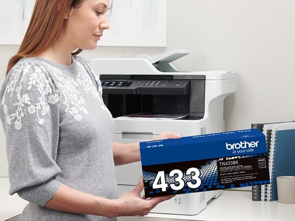 Person installing new toner cartridge into Brother laser printer