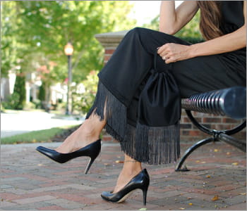 woman sitting on a park bench wearing a black skirt and heels