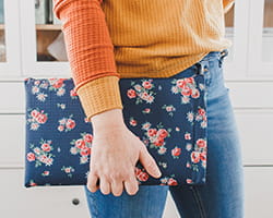 Person holding a sewn floral laptop sleeve. Sew the laptop sleeve with your Brother sewing machine. 