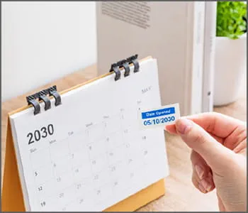 Person adding P-touch label to calendar.