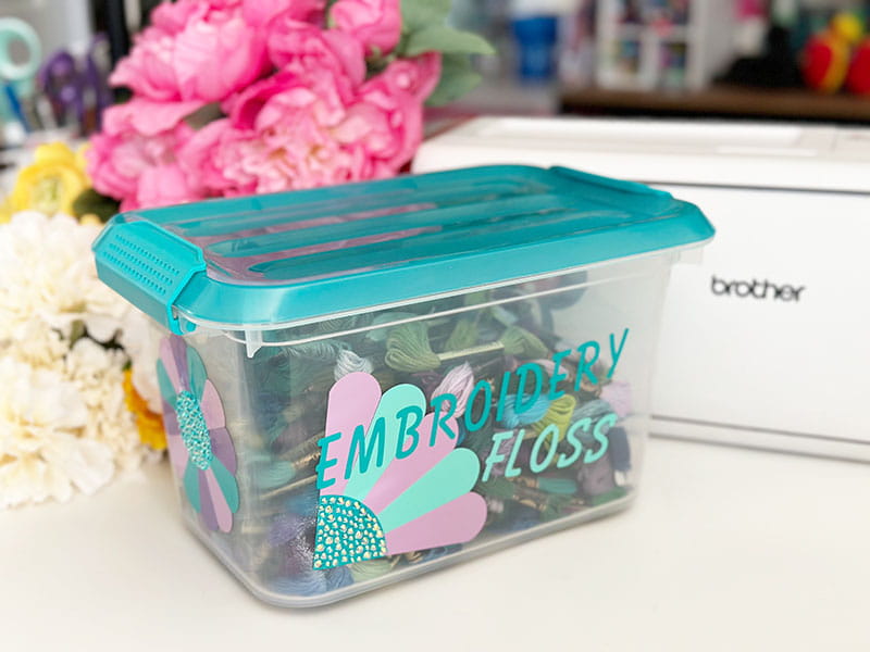 Container filled with floss that's has the outside embroidered