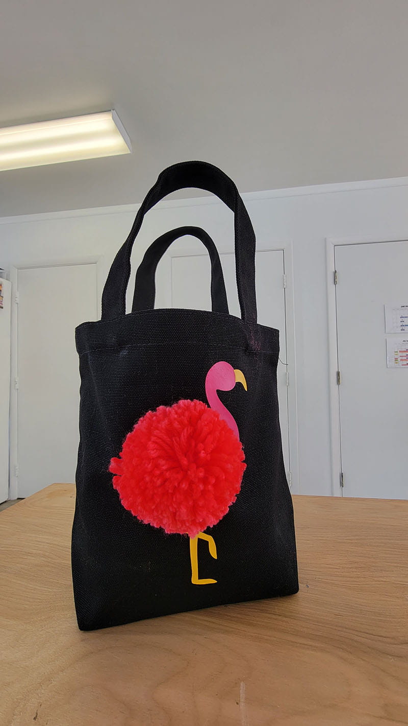 Completed flamingo tote on a wooden desk