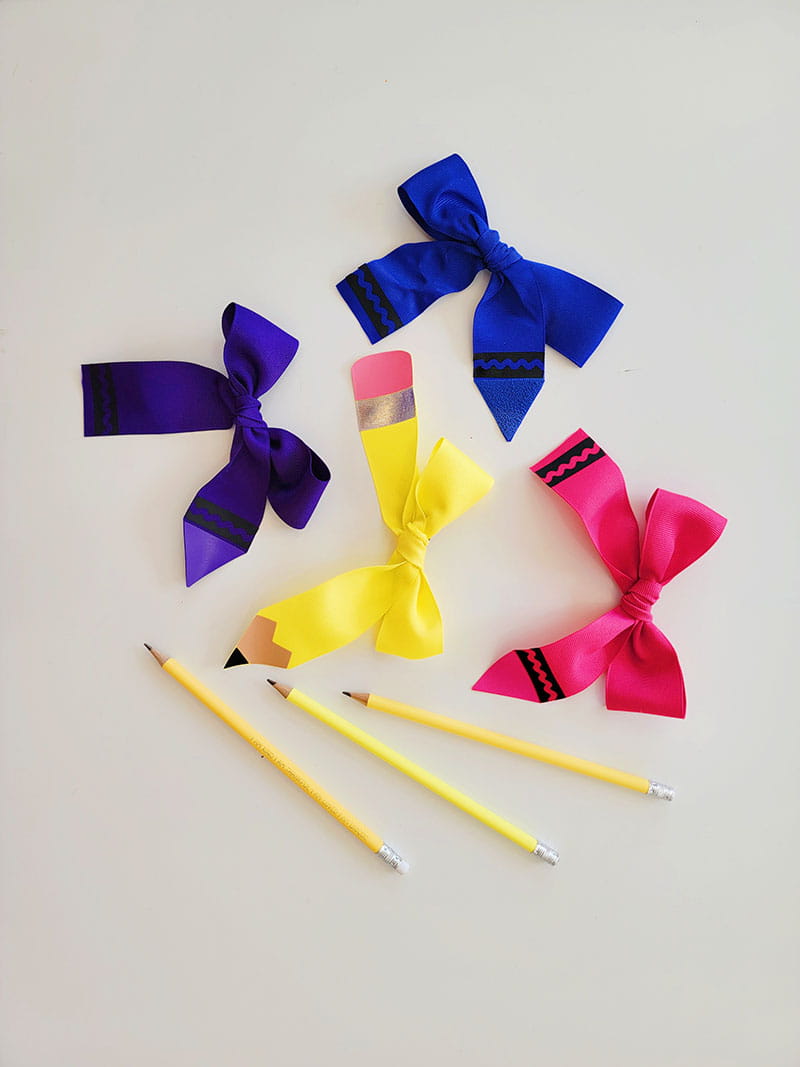Pencil and crayon bows on a gray background