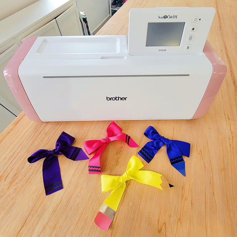 Pencil and crayon hair bows in front of Brother ScanNCut cutting machine