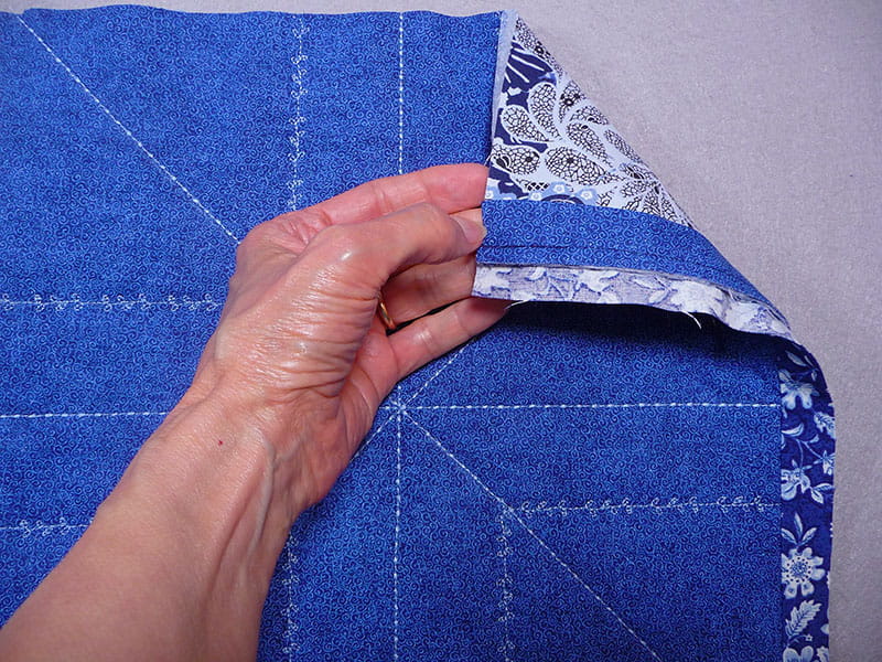 hand holding the fabric up displaying the sewed part