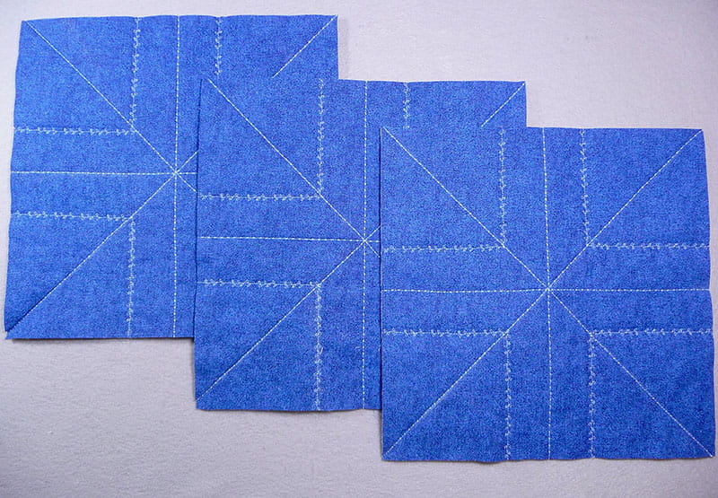 3 pieces of blue fabric laying down displaying stitching pattern throughout the fabric