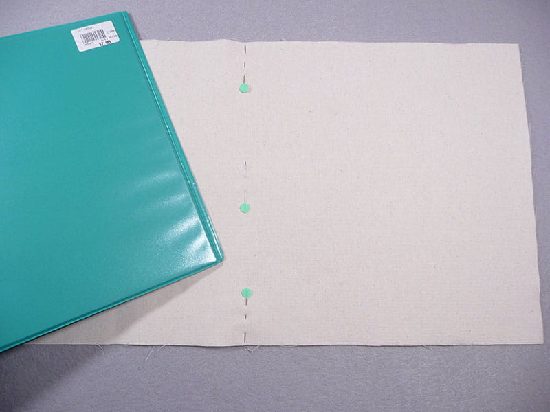 Aqua binder being placed on the fabric notebook cover