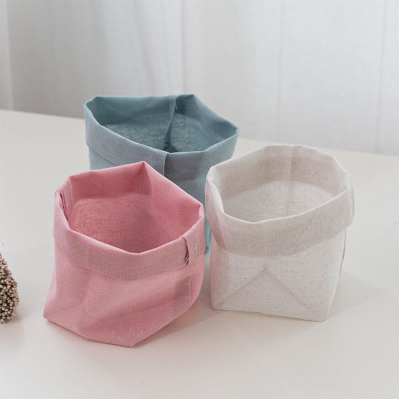 Pink, blue and white folded flower pots on a table. 