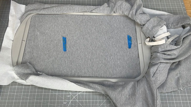 Grey sweatshirt being prepped for embroidery