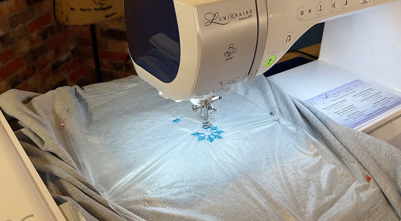 Embroidery machine on grey hooded sweatshirt