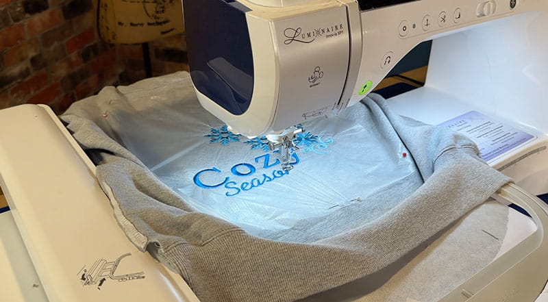 Embroidery machine on grey hooded sweatshirt