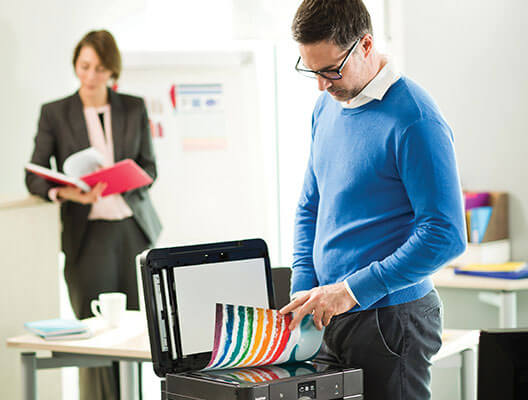 Man in blue sweater using Brother scanner