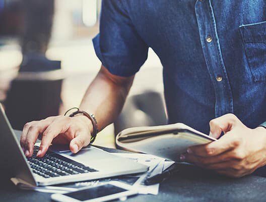 Man in denim shirt using a laptop