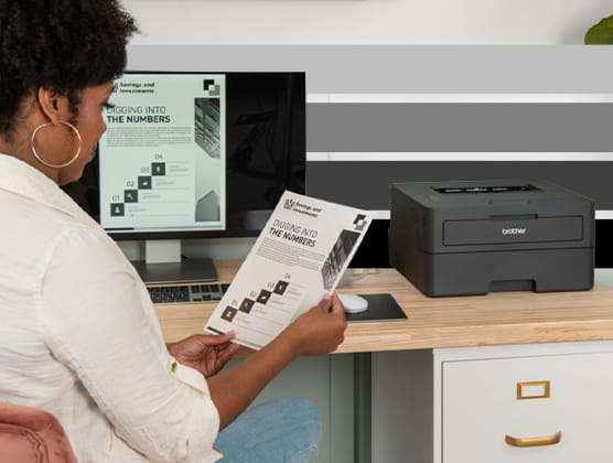 Person printing a document off computer to a Brother ELLe black and white printer.