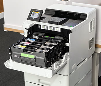 HL-L9410 printer in an office setting with toner tray open.