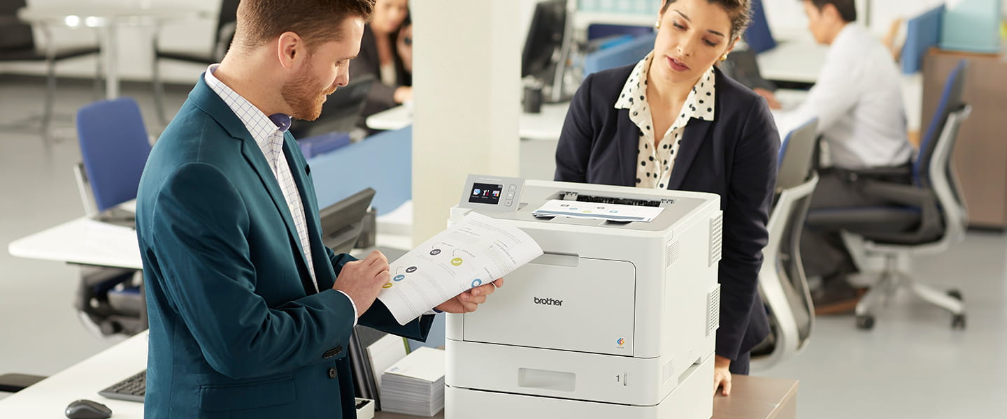 Man and woman in a medium business printing document on HL-L9310CDW color laser printer. 
