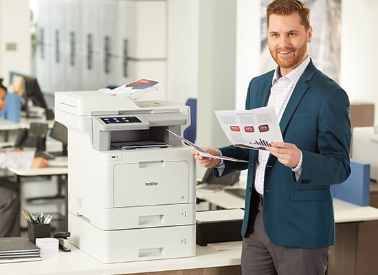 Man printing color documents in a small business setting on MFC-L9570CDW color all-in-one printer.