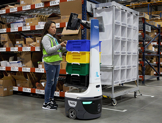 Person in a warehouse using an AMR powered by Brother Gearmotors