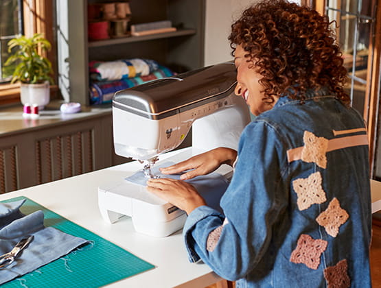 Woman using Stellaire2 sewing and embroidery machine. 