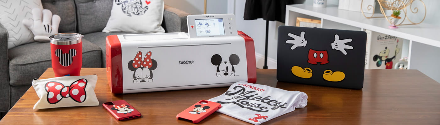 Disney ScanNCut with tumbler, pillow and phone cases on table