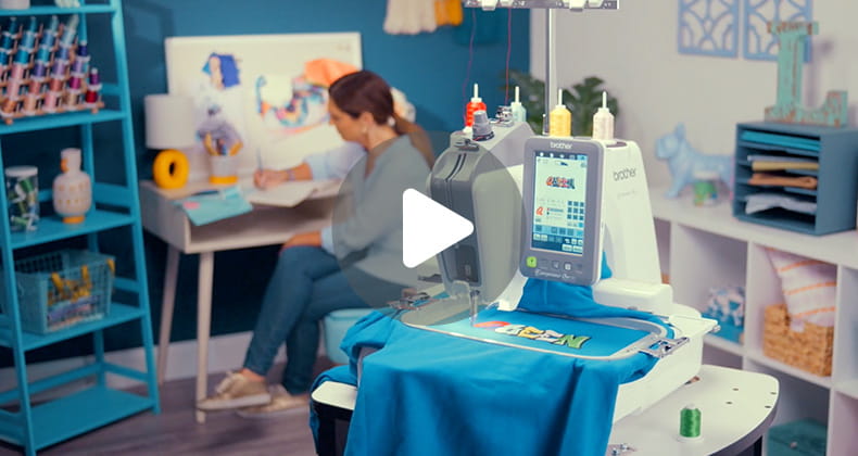 Video play button overlaid on image of PR1X in a craft room with woman designing in background. 