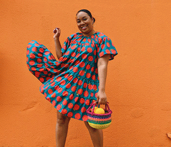 Woman modeling blue dress with large red dots