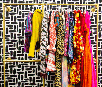 Golden coat rack with a variety of dresses and jackets hanging