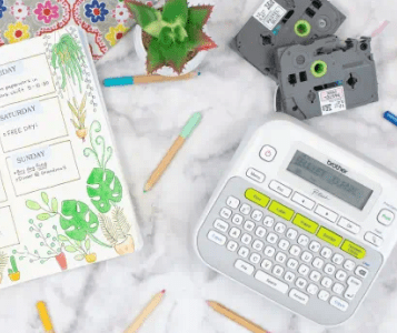 Brother Ptouch on Table with Label Tapes on Sides