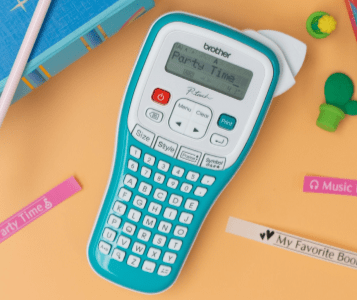 Brother Label Maker on desk with label tapes all around