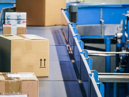 Cardboard boxes on a conveyor belt in a warehouse