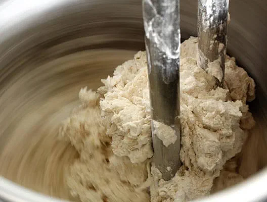 Large mixing vat turning dough with motion blur