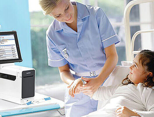 Nurse attaching wristband to young patient