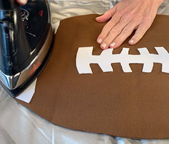 Person ironing a football placemat