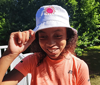 Woman wearing bucket hat with sun embroidery