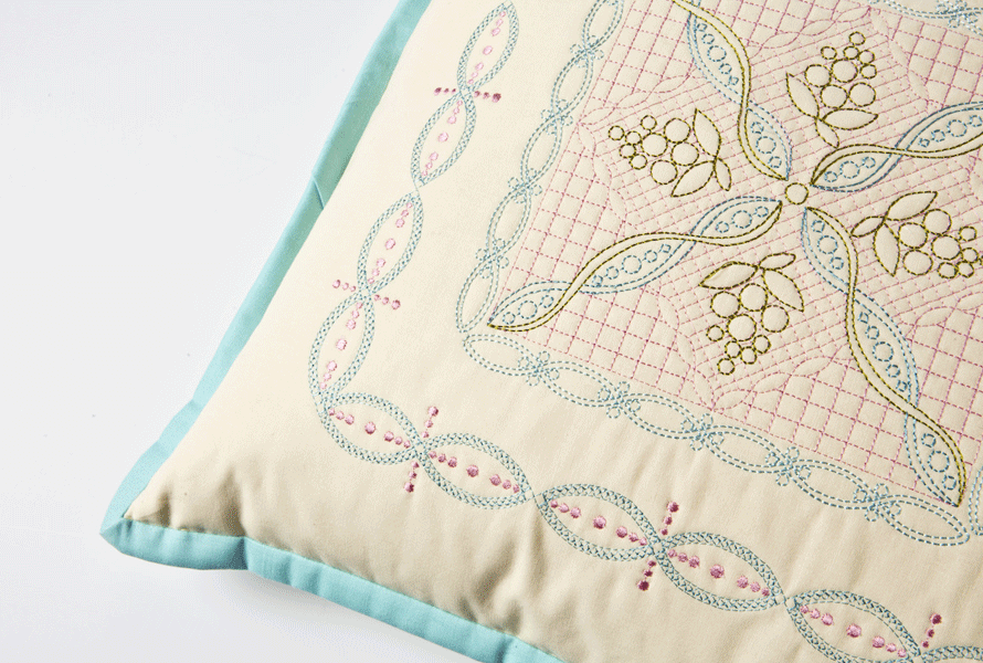 Beige pillow with blue welt and custom embroidered design