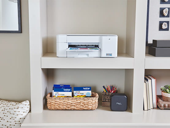 Brother printer on a shelf and Brother genuine ink and toner cartridges in basket