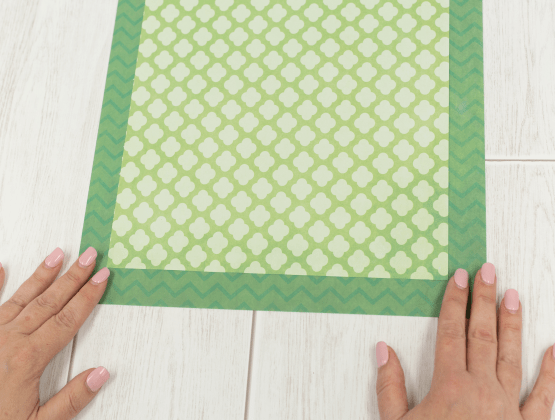 Step 2: Person aligning sheets of patterned paper for P-touch Embellish project.