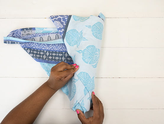 P-touch embellish craft step 3: Person covering wine bottle with the tea towel