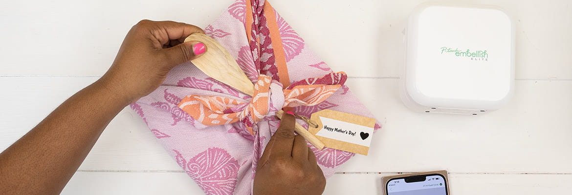 Person wrapping gift with P-touch embellish ribbon
