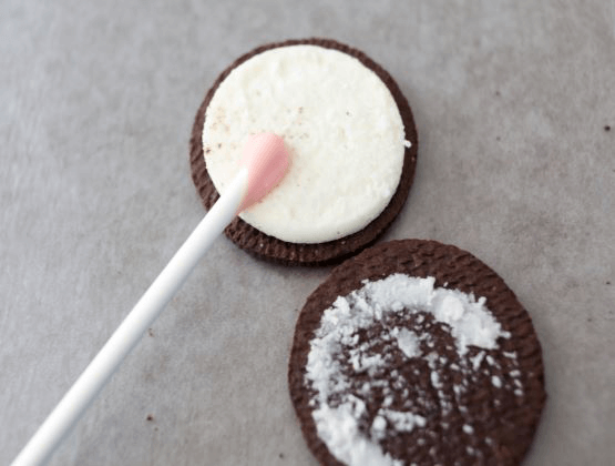 Oreo cookie separated with a lollipop stick inside.